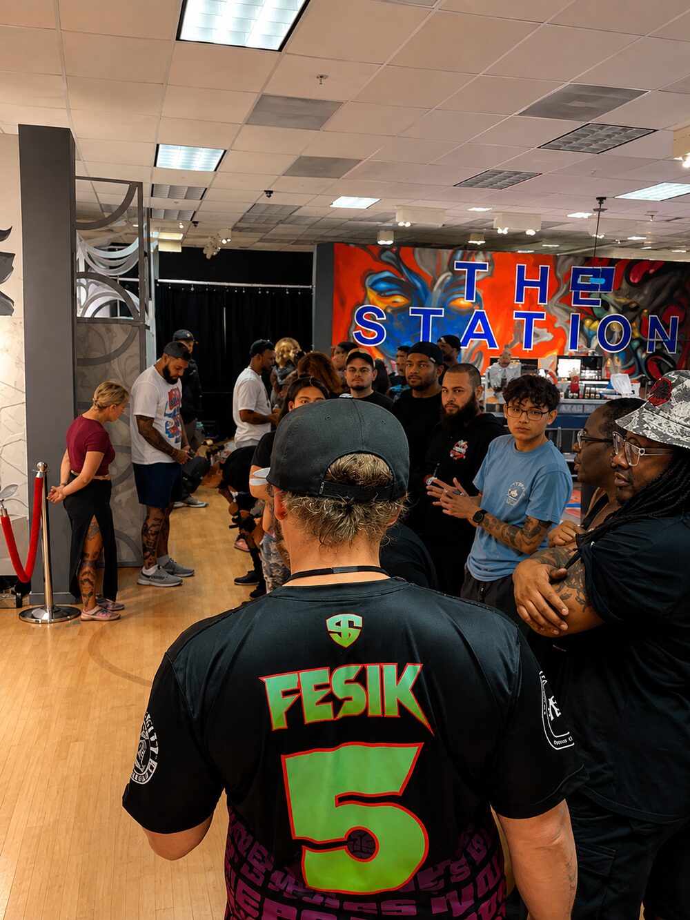 Artists and guests filling the floor in front of The Station mural