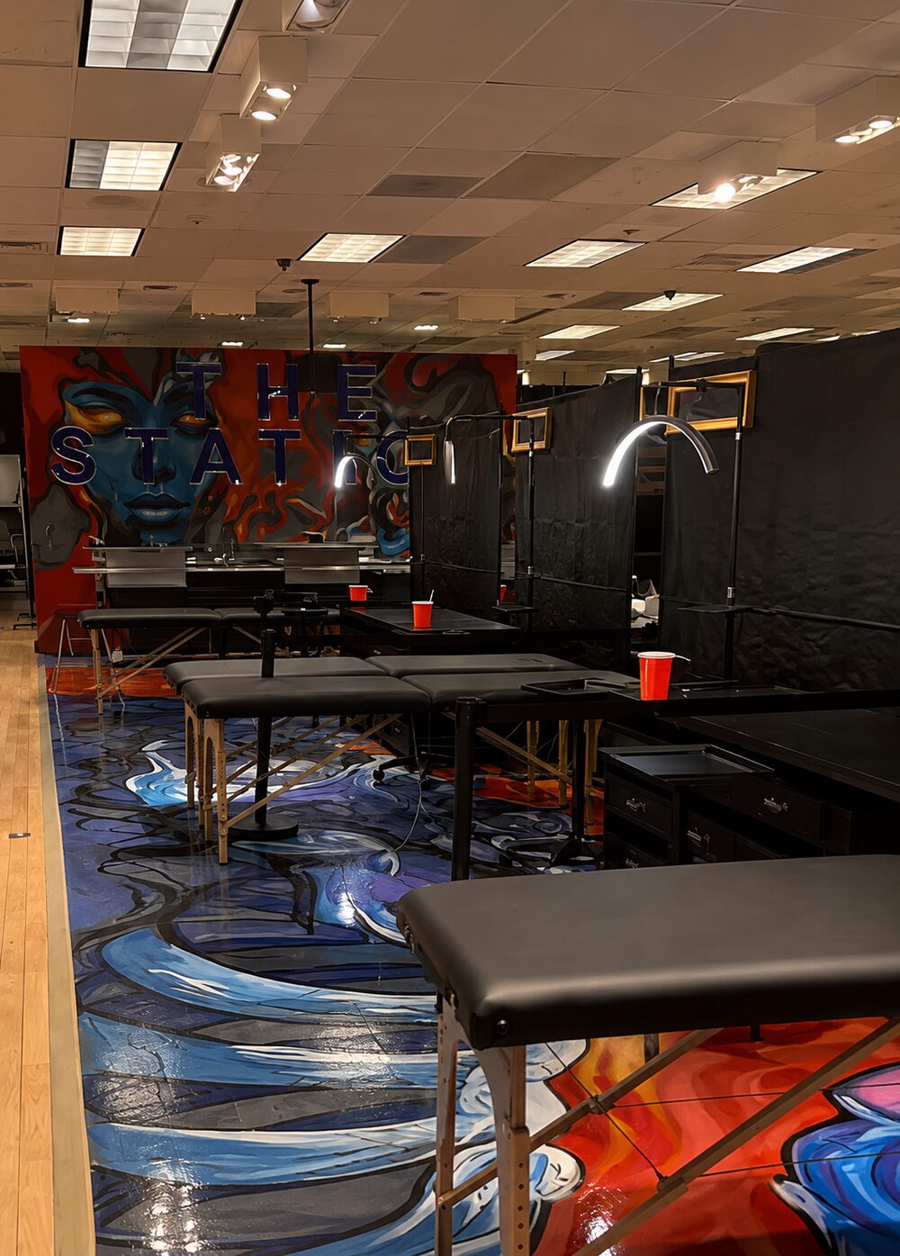 Tattoo stations set up across the painted studio floor